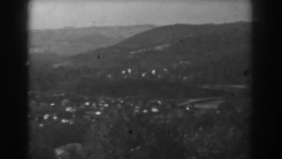 Black-and-white 1938 Vineland panorama showing low hills, scattered homes, and a faint curving road in the distance.