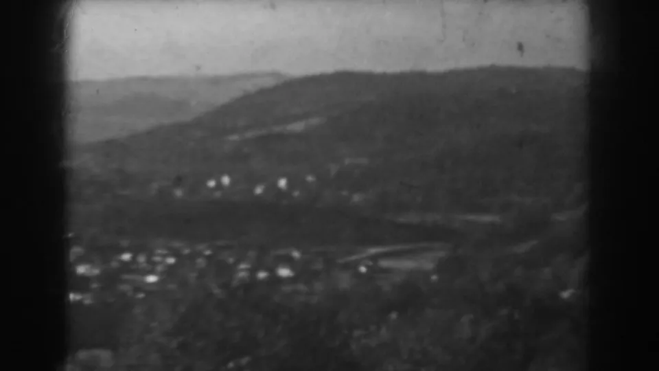 Late-1930s home-movie frame of Vineland showing a distant residential area, low hills, and visible 8mm frame edges.