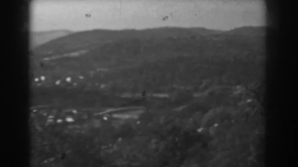 Soft 1938 home-movie frame of the Vineland, New Jersey area, with distant houses below tree-covered hills.
