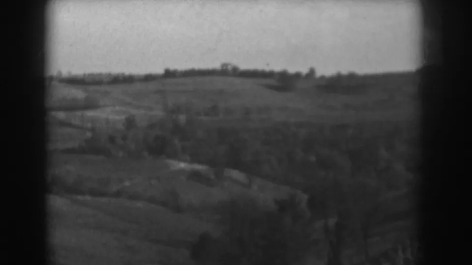 Elevated 1938 Vineland-area view of rolling fields, distant trees, and a faint road or path across the valley.