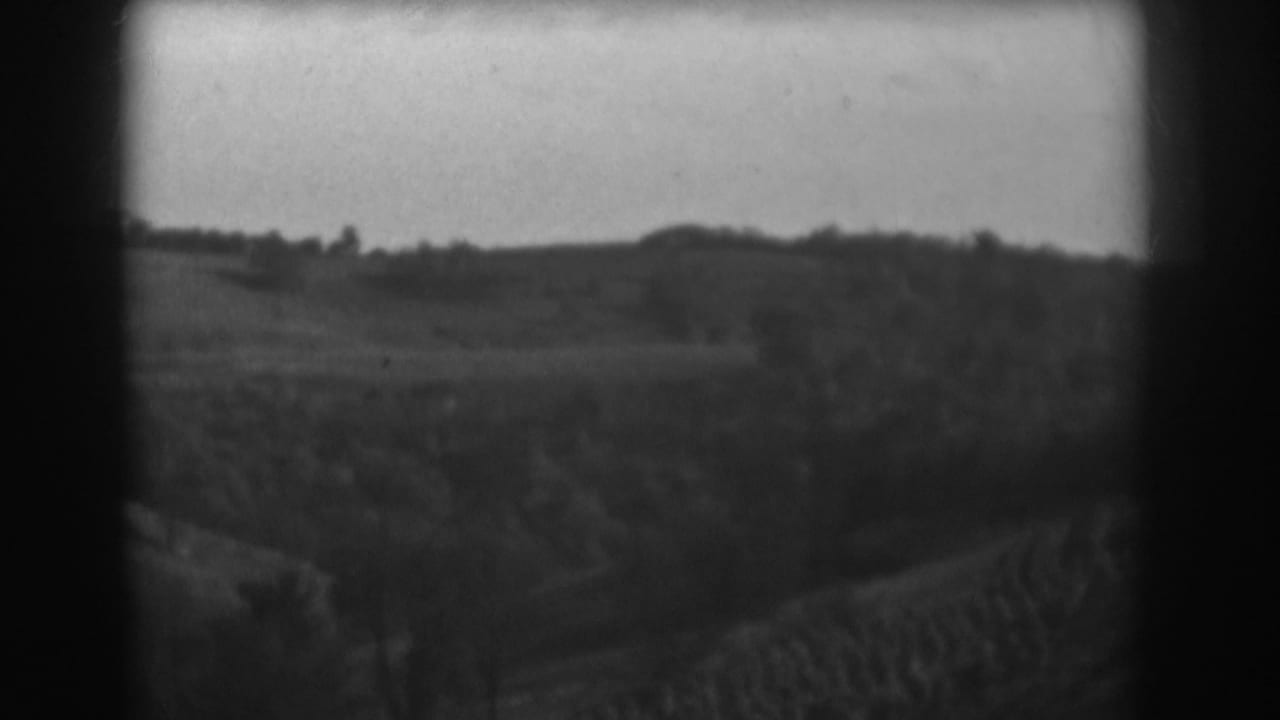 1938 Vineland, New Jersey home-movie frame showing open rural fields, low hills, and a distant tree line.