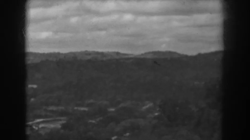 1938 Vineland, New Jersey 8mm frame with distant hills, valley buildings, trees, and heavy clouds.