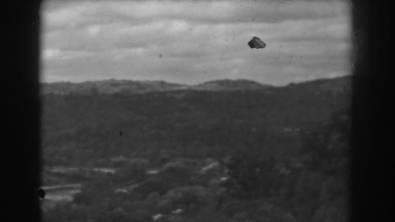 1938 8mm home-movie frame from Vineland, New Jersey, showing distant wooded hills under an overcast sky.