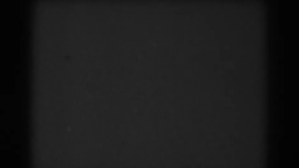 Near-black 1938 8mm frame with soft grain and little discernible subject detail near the end of the clip.