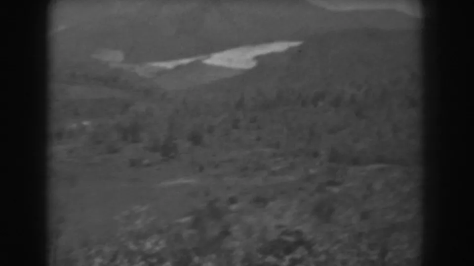 1938 West Virginia 8mm frame showing forested hills, distant ridges, and a pale winding river or waterway.