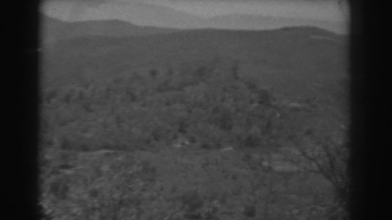 Late pan frame from 1938 West Virginia footage showing wooded hills, distant ridges, haze, and no visible people.
