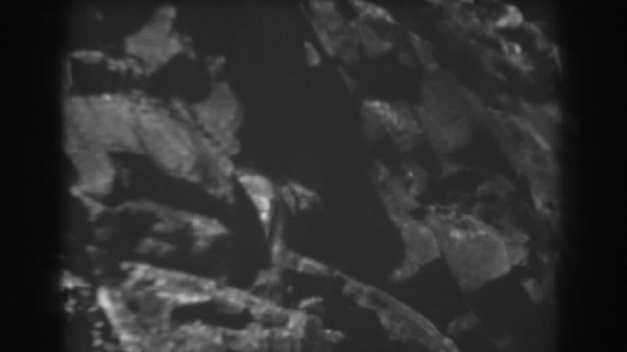 1938 West Virginia 8mm frame showing a close, grainy view of jagged rock surfaces in a mountain pass.