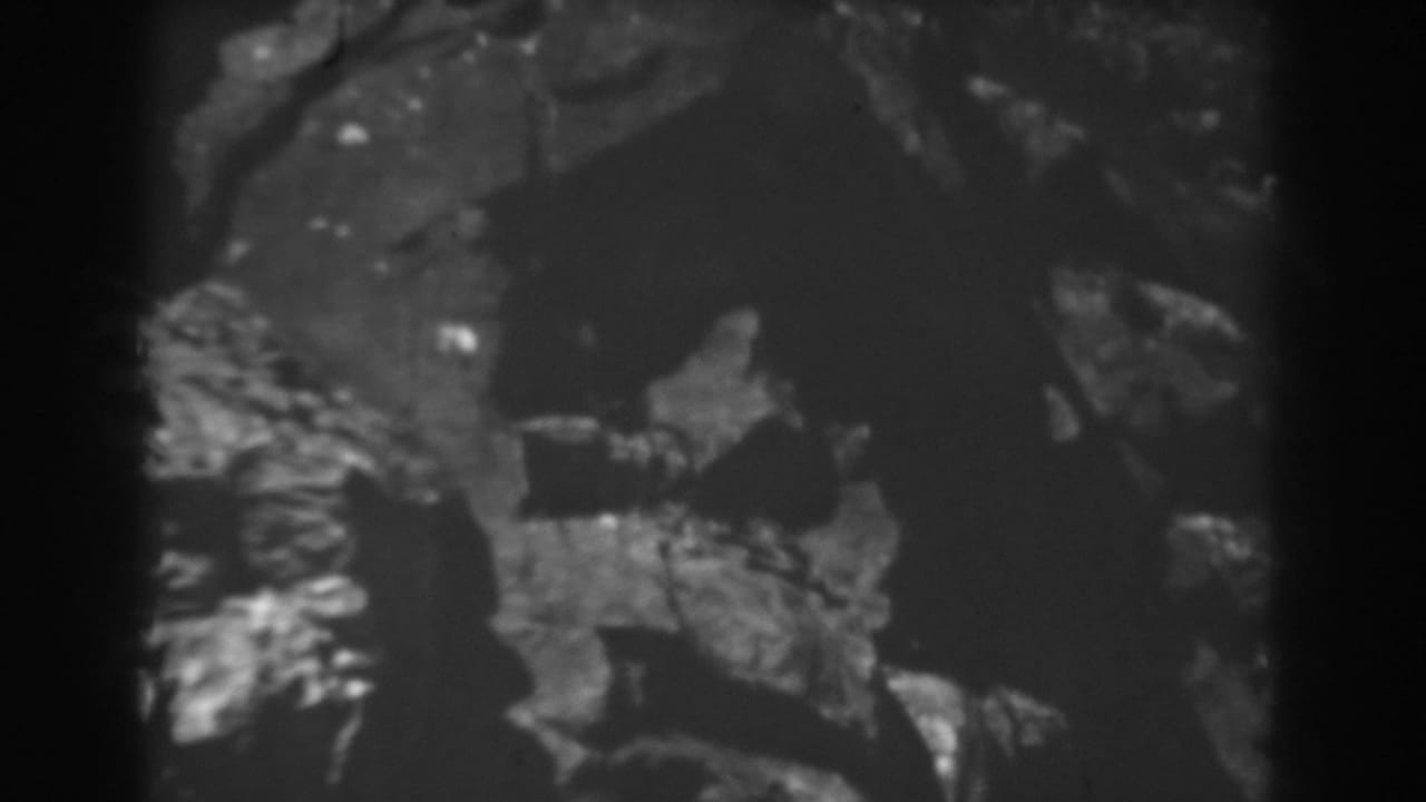 1938 West Virginia 8mm frame with rough rock formations and shadowed mountain terrain.