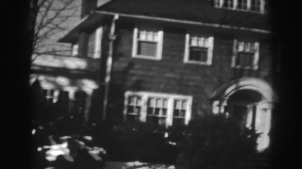 The pan reaches the arched entry of the 1938 Winchester house, with grouped windows, shrubs, and bare branches visible.