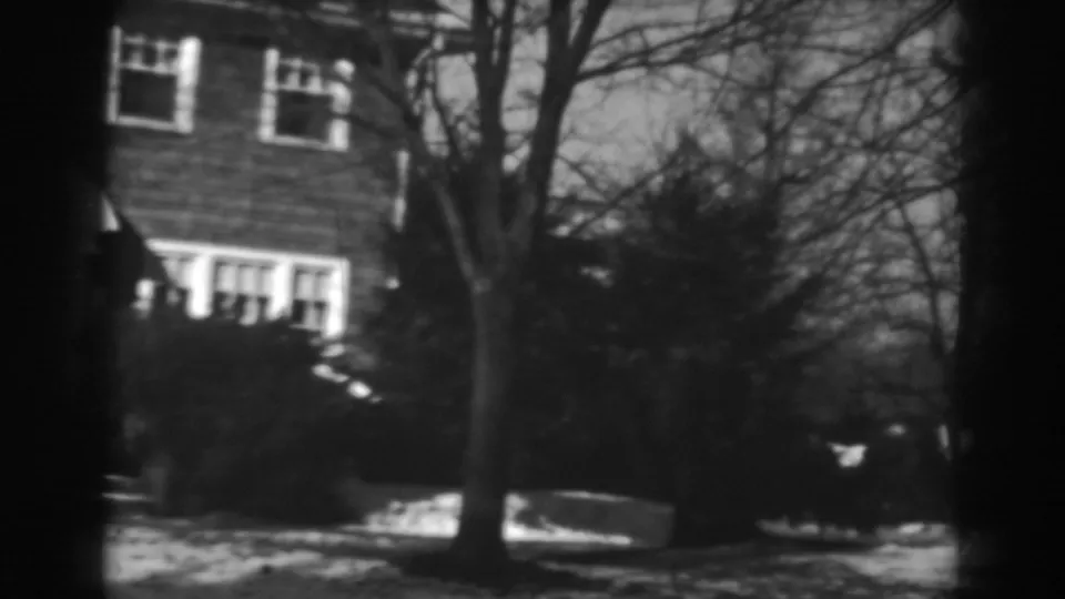 1938 Winchester, Maryland frame showing part of the brick house, a leafless tree, shrubs, and snowy ground.