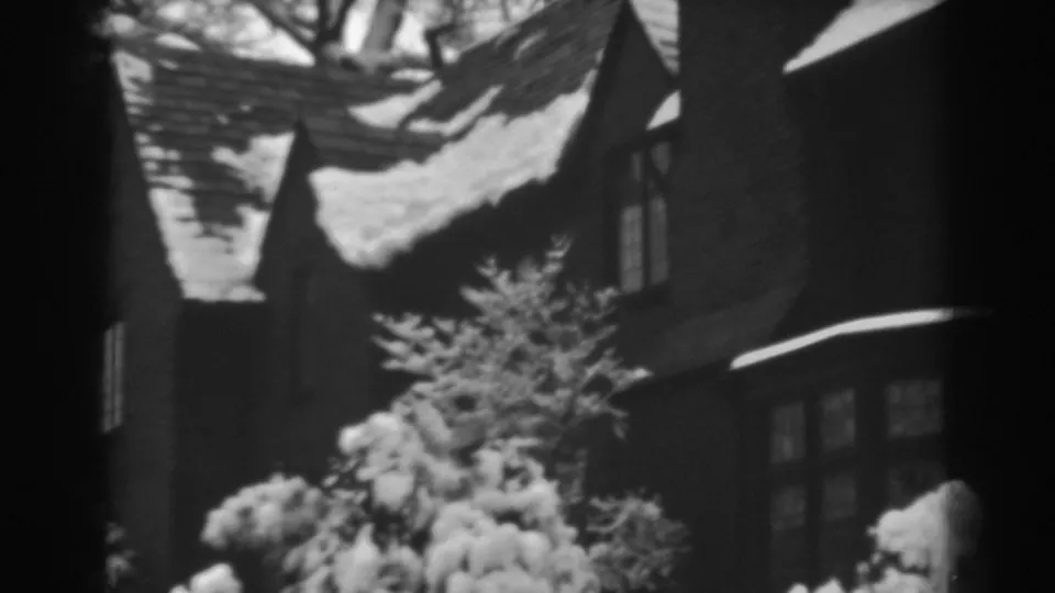 A soft 8mm view of a snow-covered residential exterior in Winchester, Maryland, with shrubs and roofline prominent.
