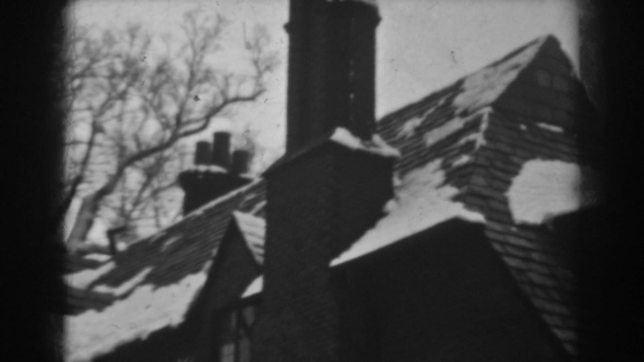 A 1938 Winchester, Maryland winter view of a house roof, chimney, and leafless trees captured on 8mm film.