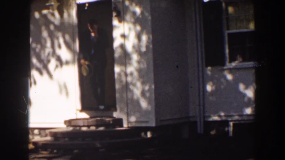 In the 1939 Mount Washington footage, a suited adult man stands near the open door and appears to hold a brimmed hat.