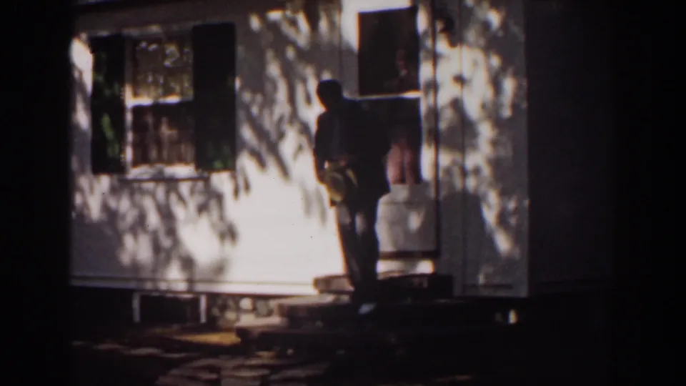 The man appears to turn back near the doorway, with porch steps and shuttered windows visible in the Mount Washington home scene.