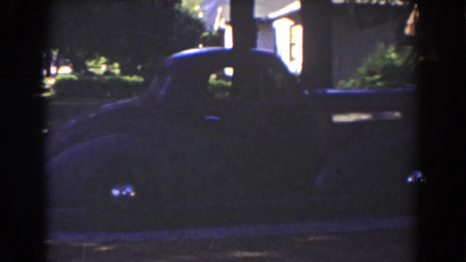 A dark vintage car appears parked near a residential property in the 1939 Mount Washington home-movie footage.