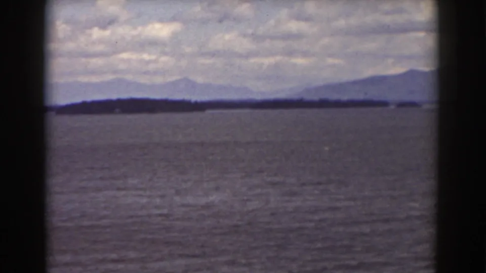 Late-frame 8mm view of water and distant mountain silhouettes in the supplied 1939 Mount Washington, New Hampshire clip.
