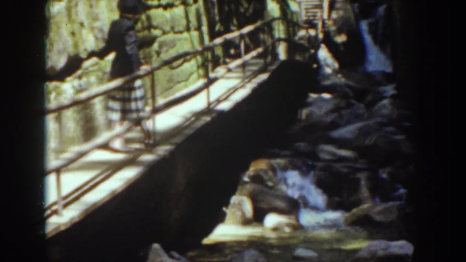 The visitor remains on the bridge as water moves through rocks below in this 1939 Mount Washington home-movie view.