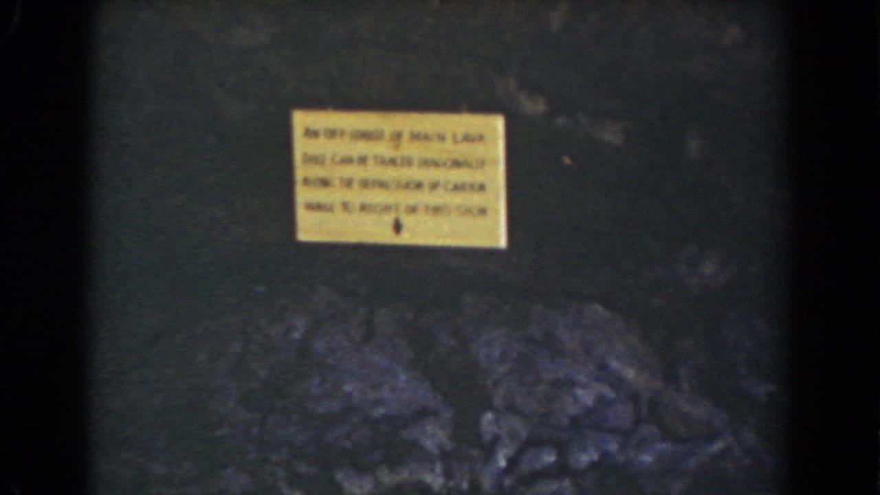 1939 Mount Washington 8mm frame with a yellow warning sign above rugged dark rock formations.