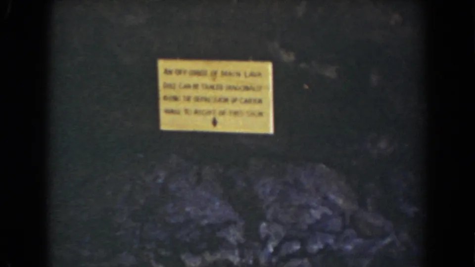 1939 Mount Washington 8mm frame with a yellow warning sign above rugged dark rock formations.