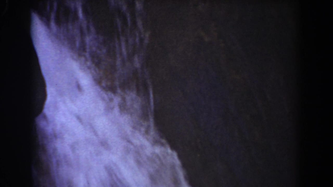 Close waterfall detail from 1939 Mount Washington footage, with pale water spreading over rough stone.