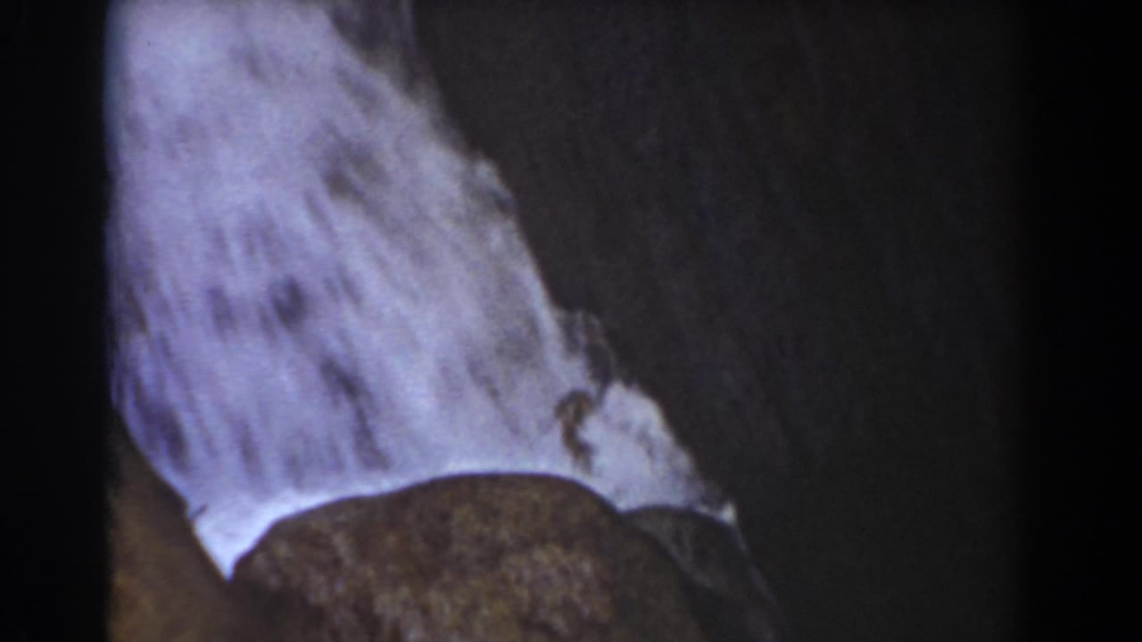 1939 8mm travel footage shows water cascading over rock near the Flume Boulder landmark in New Hampshire.