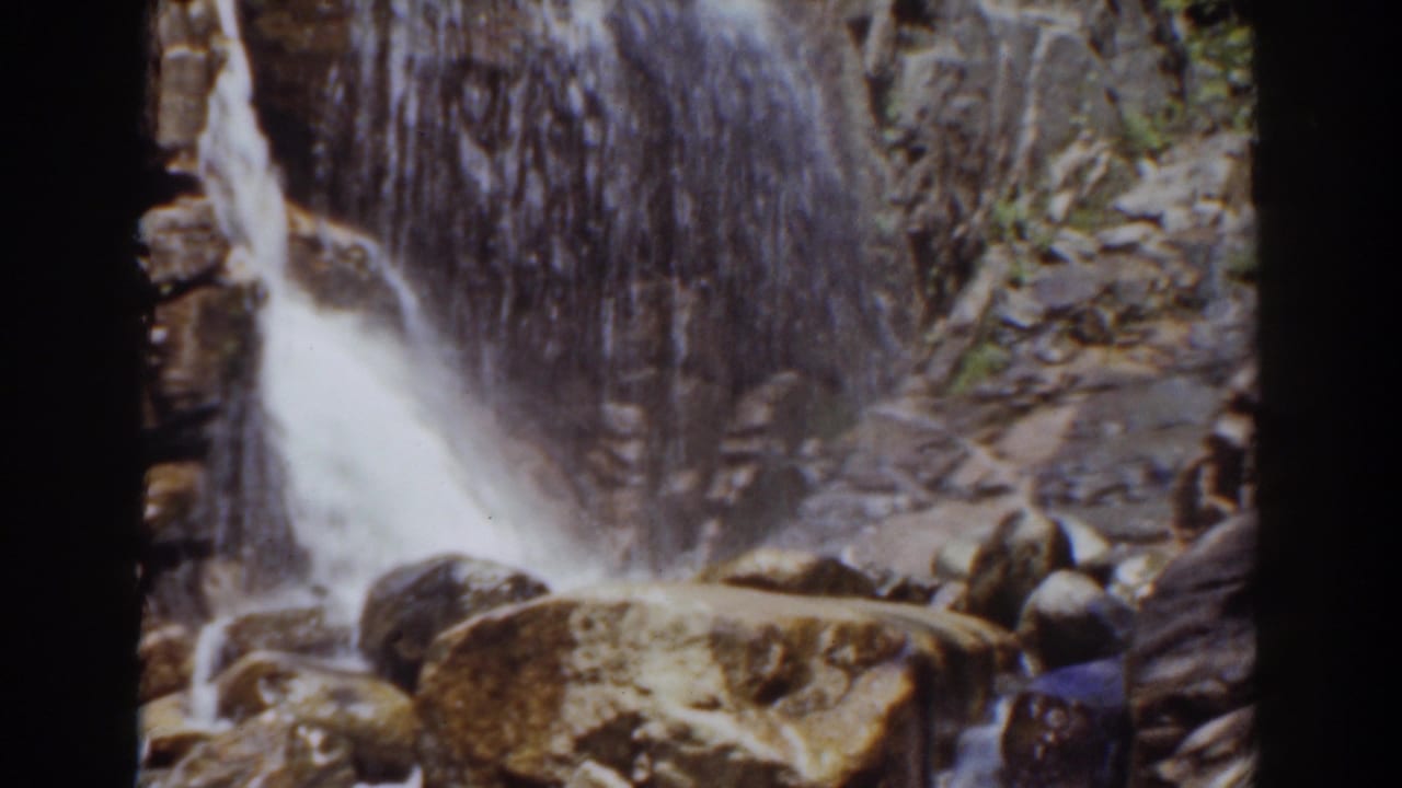 The 8mm frame shows the Mount Washington waterfall spilling past a rock wall and large foreground boulder.