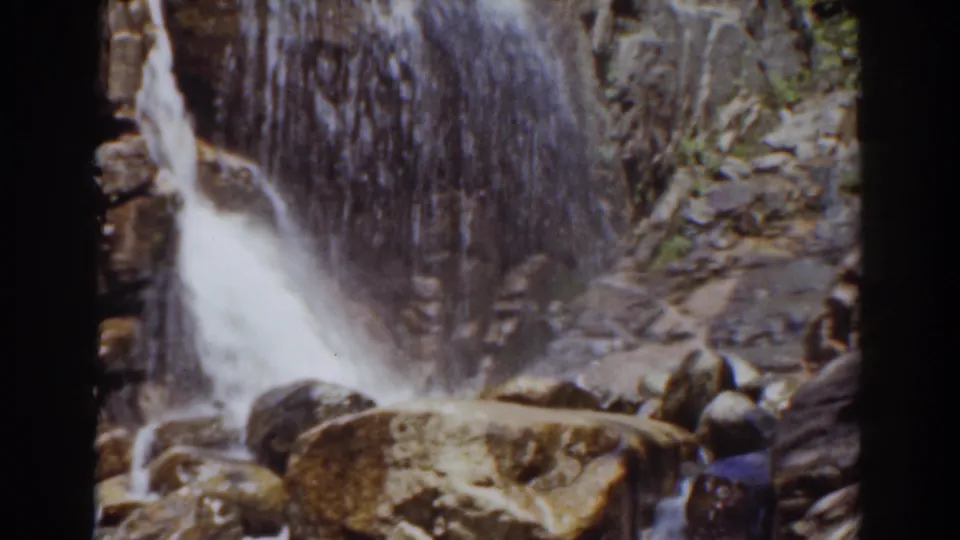The 8mm frame shows the Mount Washington waterfall spilling past a rock wall and large foreground boulder.