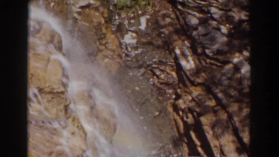 1939 8mm frame from Mount Washington showing white water running over textured rock and shadowed cracks.