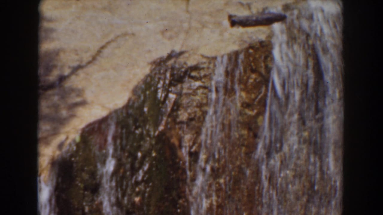 Close 8mm view of rushing water and wet rock ledges in the Mount Washington stream sequence.