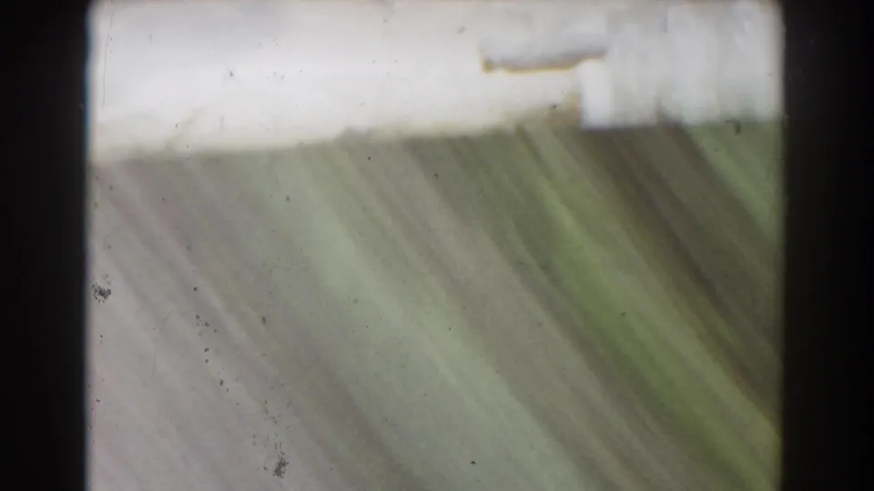 Soft, abstract end frame from the 1939 Mount Washington stream shot, with greenish water or wet stone and visible film dust.