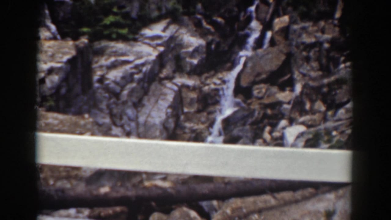 A white overlook railing frames a rocky cascade in the Mount Washington, New Hampshire home-movie scene.