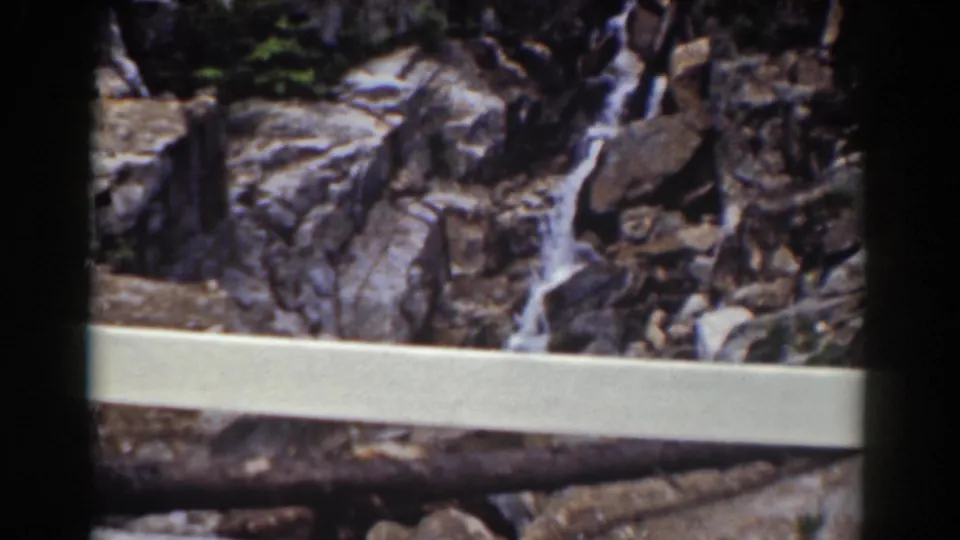 A white overlook railing frames a rocky cascade in the Mount Washington, New Hampshire home-movie scene.