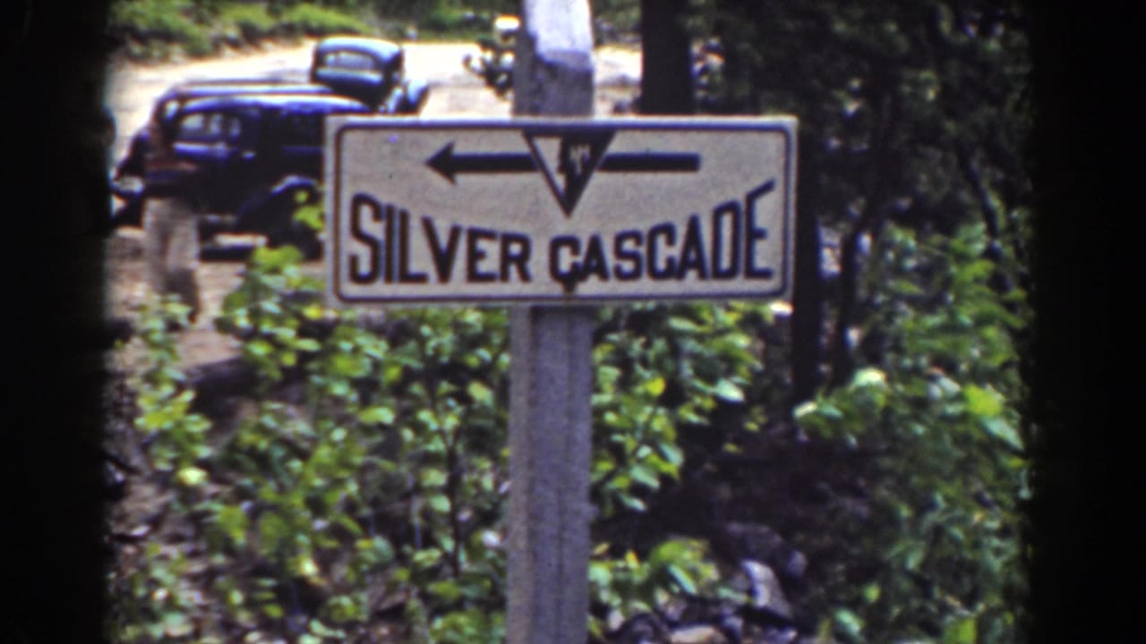 A roadside sign reading Silver Cascade stands near parked vintage automobiles in Mount Washington, New Hampshire.