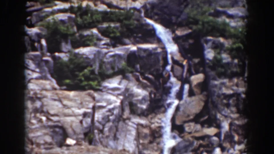1939 New Hampshire home-movie view of cascading water crossing boulders and ledges in a forested mountain area.