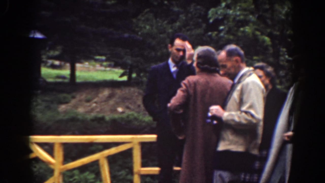 Adults in coats and suits stand by a yellow bridge railing at a Mount Washington scenic overlook in 1939 home-movie footage.