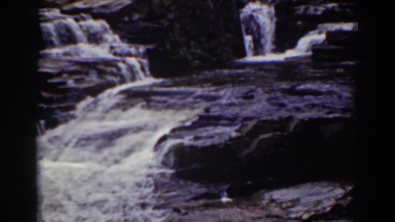 A steady 8mm view of Mount Washington water spilling over broad, dark stone shelves in 1939.