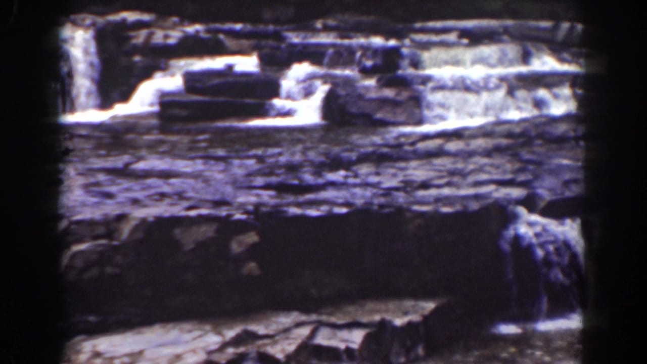 Mount Washington, New Hampshire frame with water crossing flat rock shelves and spilling through narrow gaps.
