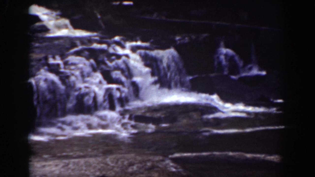 Final 8mm frame of the Mount Washington waterfall, with white water spreading across dark rock shelves.
