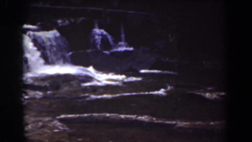 1939 Mount Washington footage shows water running over broad rock ledges beneath dark surrounding trees.