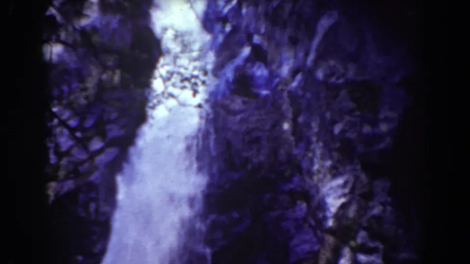 Mount Washington waterfall seen in aged 8mm color, with water pouring past rough cliff surfaces.