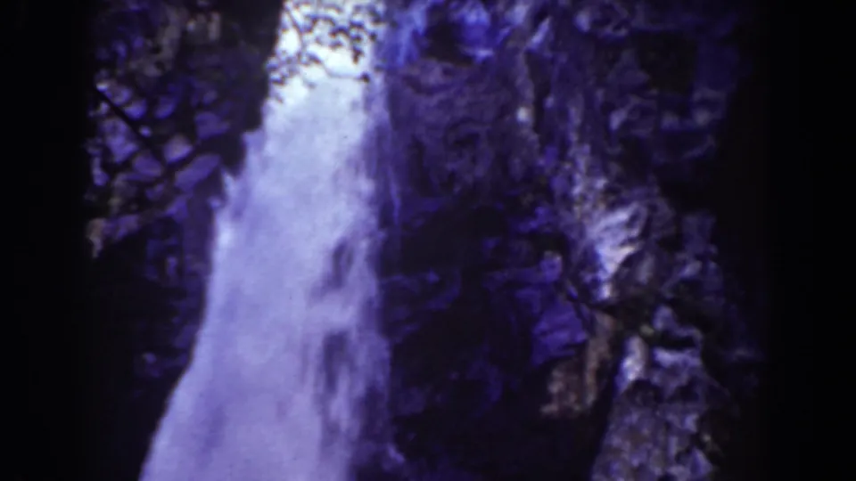 A home-movie frame shows the waterfall filling the lower view, bordered by steep Mount Washington rock.