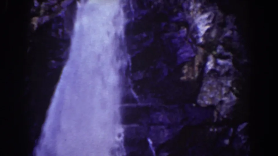 1939 Mount Washington home-movie frame showing white waterfall flow against dark rocky cliff surfaces.