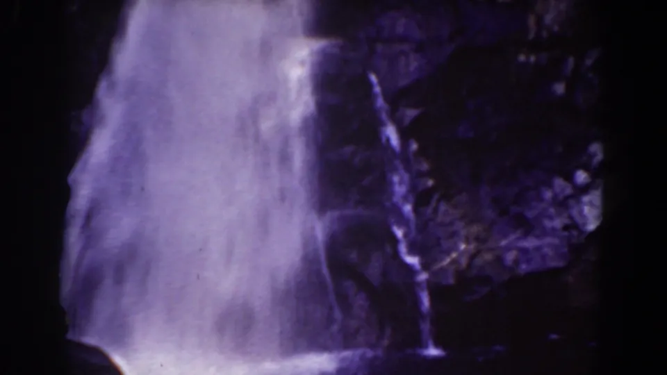 1939 home-movie still showing a waterfall curtain framed by shadowed rock on Mount Washington, New Hampshire.