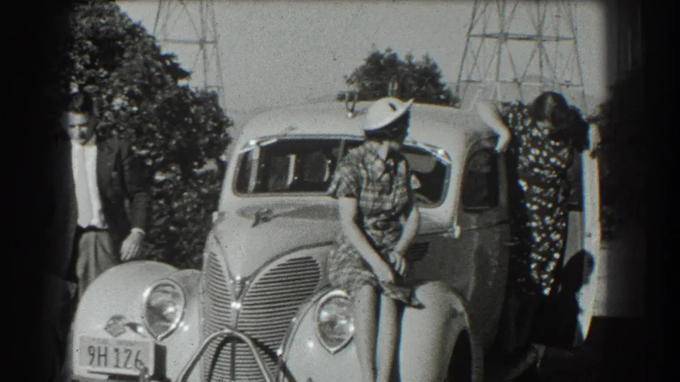 The 1939 San Francisco scene shows the group shifting poses around the sedan, with the woman by the open door.