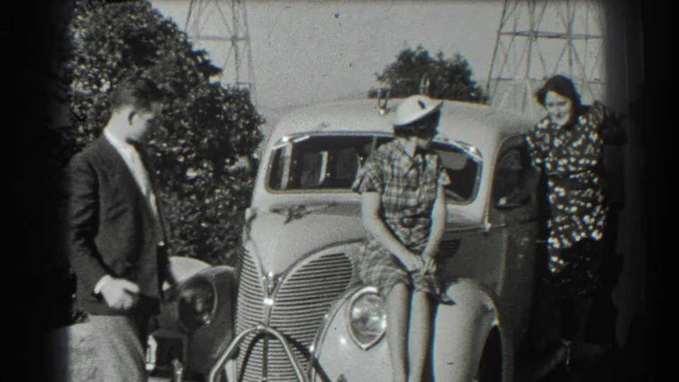 Near the end of the 1939 San Francisco clip, the man steps closer while the others stay posed around the sedan.