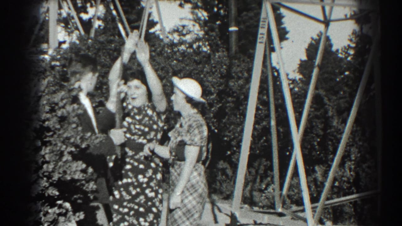 A woman raises her hands while a man with a prop gun and another woman stand beside her.