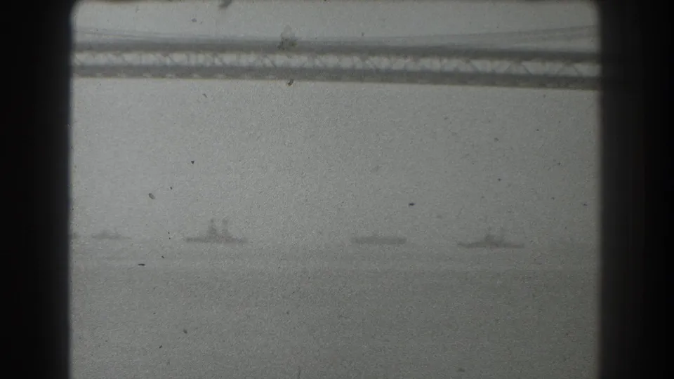 Hazy 1939 San Francisco bay view with a suspension bridge span across the upper frame and several distant ships on the water below.