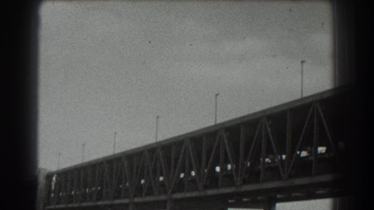 1939 8mm view of the Golden Gate Bridge from below, showing trusswork, cables, and dark film borders.