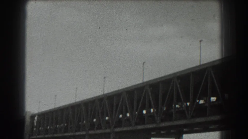 1939 8mm view of the Golden Gate Bridge from below, showing trusswork, cables, and dark film borders.