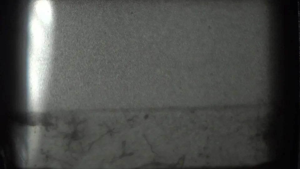 Late frame from the 1939 San Francisco clip showing a pale surface, bright flare, grain, and dark 8mm frame edges.